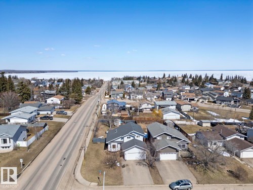 Residential neighborhood featuring a paved street, established homes, and a distant body of water - 1414 7 Avenue, Cold Lake, AB - Outdoor With View
