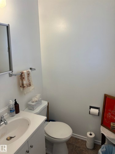 Bathroom featuring a white vanity with an integrated sink, chrome faucet, and coordinating mirror - 4824 49 Avenue, Sangudo, AB - Indoor Photo Showing Bathroom