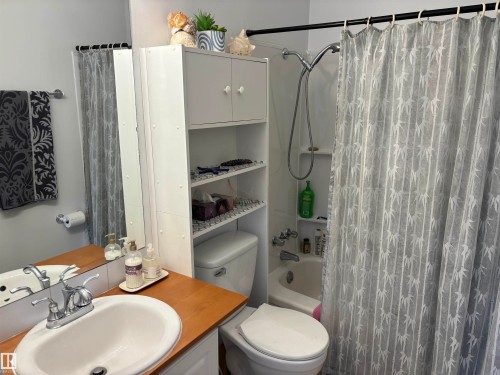 Bathroom featuring a white vanity with a wood-finish countertop and an oval drop-in sink - 4824 49 Avenue, Sangudo, AB - Indoor Photo Showing Bathroom