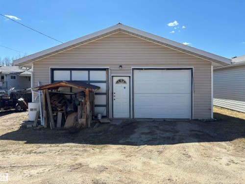Detached two-car garage featuring tan horizontal siding and a white trim - 4824 49 Avenue, Sangudo, AB - Outdoor