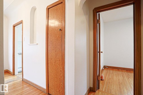Hallway featuring wood-finish flooring, white walls, and wood-paneled doors with matching trim - 9611 81 Avenue, Edmonton, AB - Indoor Photo Showing Other Room