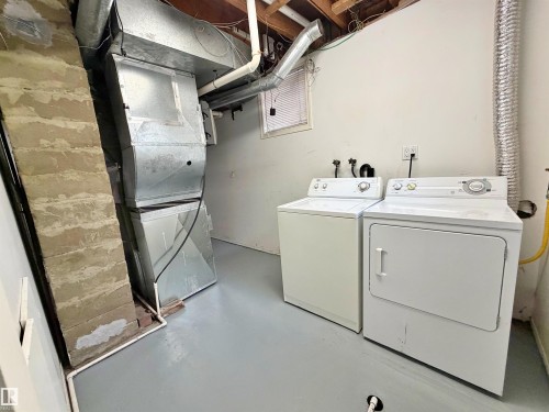 Dedicated laundry area featuring a white top-load washing machine and front-load dryer - 9611 81 Avenue, Edmonton, AB - Indoor Photo Showing Laundry Room