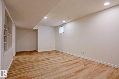 Spacious room featuring wood-finish flooring, recessed lighting, and built-in shelving - 9611 81 Avenue, Edmonton, AB - Indoor Photo Showing Other Room