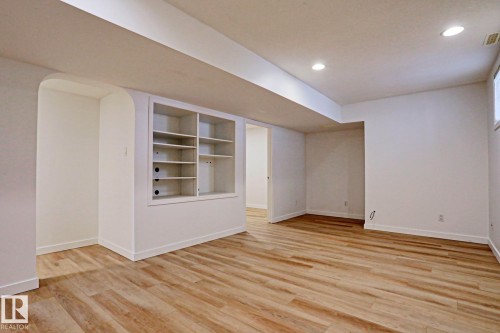 Spacious interior featuring wood-finish flooring, recessed lighting, and bright white walls - 9611 81 Avenue, Edmonton, AB - Indoor Photo Showing Other Room