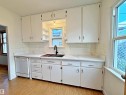 Kitchen featuring white cabinetry, light-toned patterned backsplash, a white dishwasher, and wood-finish flooring - 9611 81 Avenue, Edmonton, AB  - Indoor Photo Showing Kitchen 