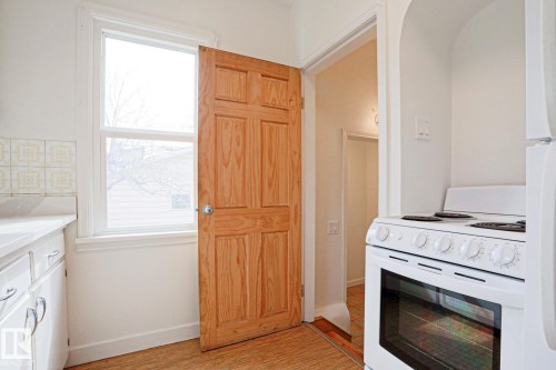 Kitchen space featuring white cabinetry, a single-pane window, and a white electric range - 9611 81 Avenue, Edmonton, AB - Indoor