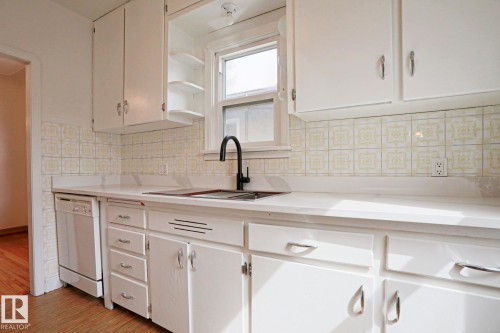 White kitchen cabinetry with complementary tile backsplash - 9611 81 Avenue, Edmonton, AB - Indoor Photo Showing Kitchen