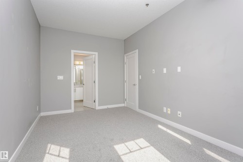 The room features gray walls, gray carpeting, and white baseboards - 211 10808 71 Avenue, Edmonton, AB - Indoor Photo Showing Other Room