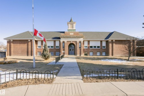 The property features a traditional brick exterior with a prominent central entrance and a cupola - 211 10808 71 Avenue, Edmonton, AB - Outdoor