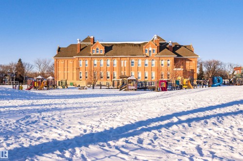 The property features a large brick exterior with multiple windows, set against a clear sky - 211 10808 71 Avenue, Edmonton, AB - Outdoor