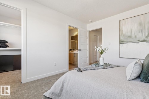 Carpeted bedroom with a built-in closet featuring shelving and a hanging rod - 39 Caledon Crescent, Spruce Grove, AB - Indoor Photo Showing Bedroom