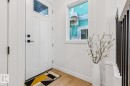 Entryway featuring a white paneled door with matte black hardware, transom window, and light wood-finish flooring - 39 Caledon Crescent, Spruce Grove, AB  - Indoor Photo Showing Other Room 