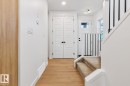 Entryway featuring light wood-finish flooring, white walls, and a staircase with carpeted treads and black metal balusters - 39 Caledon Crescent, Spruce Grove, AB  - Indoor Photo Showing Other Room 
