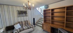 Staircase featuring wrought iron railing and carpeted treads - 