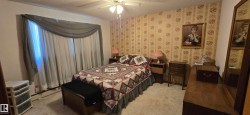 Window with sheer and draped treatments, wall-to-wall carpeting, and a ceiling fan with integrated lighting - 