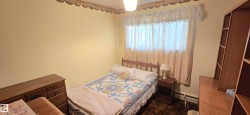 Room featuring light yellow walls, a window with beige curtains, and a ceiling light fixture - 