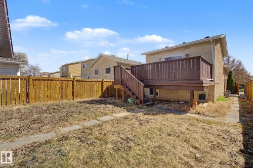 Rear exterior featuring an elevated wood deck with stairs, a sliding glass door, and stucco siding - 4106 38 Street, Edmonton, AB - Outdoor
