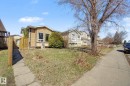 Exterior property featuring tan siding, a concrete pathway, a wooden fence, and established landscaping - 4106 38 Street, Edmonton, AB  - Outdoor 