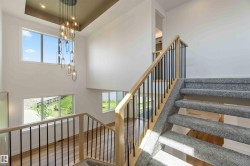 Split-level staircase featuring gray carpeting and light wood handrails with black metal balusters - 