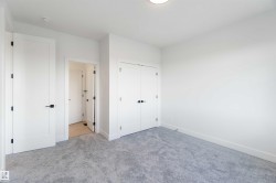 Spacious room featuring light gray carpeting, white walls, white baseboards, and a flush mount ceiling light - 