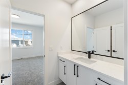 Contemporary vanity featuring a rectangular undermount sink, quartz countertop, matte black faucet, and a large framed mirror - 