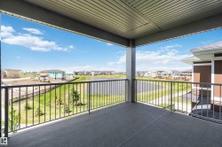 Spacious covered balcony featuring a concrete surface and black metal railings - 