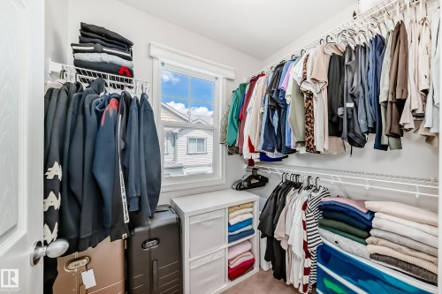 Walk-in closet with multiple levels of wire shelving and hanging rods - 45 4850 Terwillegar Common, Edmonton, AB - Indoor With Storage