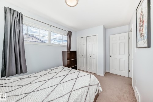 Bedroom featuring light blue walls, carpet flooring, a multi-pane window, and a flush mount ceiling light fixture - 45 4850 Terwillegar Common, Edmonton, AB - Indoor Photo Showing Bedroom