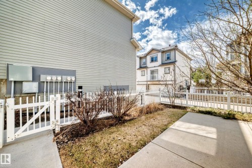 Picket fence enclosing a narrow grassy area with concrete walkway - 45 4850 Terwillegar Common, Edmonton, AB - Outdoor With Deck Patio Veranda