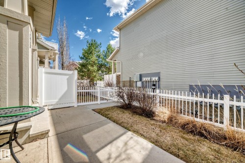 Concrete patio with a white privacy fence and picket fencing - 45 4850 Terwillegar Common, Edmonton, AB - Outdoor With Deck Patio Veranda With Exterior