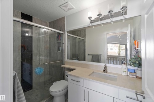 Bathroom featuring a glass-enclosed shower, a vanity with a rectangular sink, and a large mirror - 1017 82 Street, Edmonton, AB - Indoor Photo Showing Bathroom