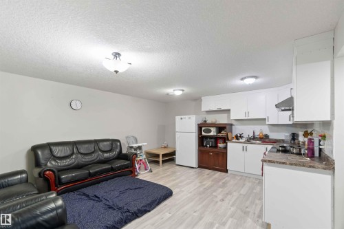 This property features an open-concept living area with light-colored flooring and a kitchen space - 1017 82 Street, Edmonton, AB - Indoor Photo Showing Kitchen