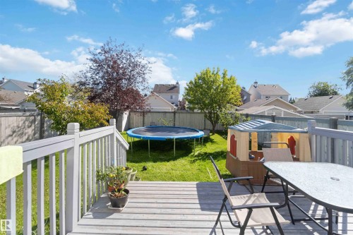 The property features a spacious backyard with a well-maintained lawn and mature trees - 1017 82 Street, Edmonton, AB - Outdoor With Deck Patio Veranda