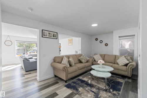 The living area features light-toned flooring, recessed lighting, and a window with blinds - 1017 82 Street, Edmonton, AB - Indoor Photo Showing Living Room
