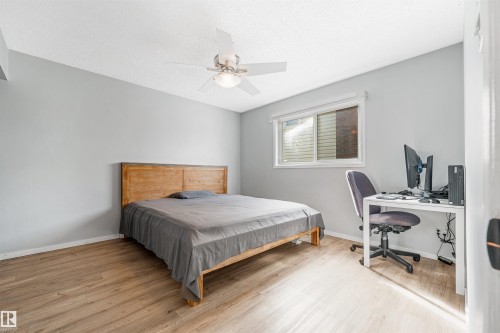 Room featuring wood-finish flooring, light grey walls, and a white ceiling fan with integrated lighting - 2437 89 Street, Edmonton, AB 