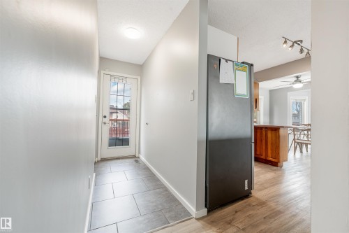 Entryway featuring contemporary gray tile flooring, a glass-paneled exterior door, and recessed lighting - 2437 89 Street, Edmonton, AB 