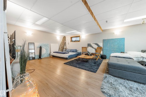Spacious room featuring wood-finish flooring, recessed lighting, and light-toned walls - 2437 89 Street, Edmonton, AB 