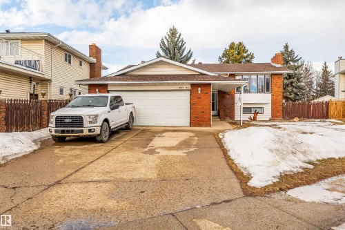 Brick and siding exterior featuring a prominent two-car garage - 2437 89 Street, Edmonton, AB 