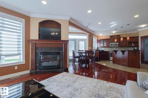 Living area featuring a dark wood mantel fireplace with a black stone surround and hearth - 10731 150 Street Nw, Edmonton, AB - Indoor With Fireplace