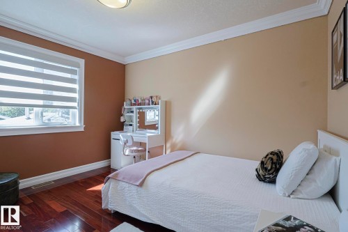 Hardwood flooring throughout, featuring a white window frame with horizontal blinds, and crown molding - 10731 150 Street Nw, Edmonton, AB - Indoor Photo Showing Bedroom