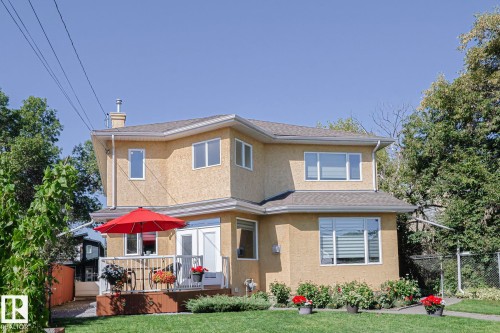 Two-story stucco exterior featuring multiple windows and a front yard with mature landscaping - 10731 150 Street Nw, Edmonton, AB - Outdoor