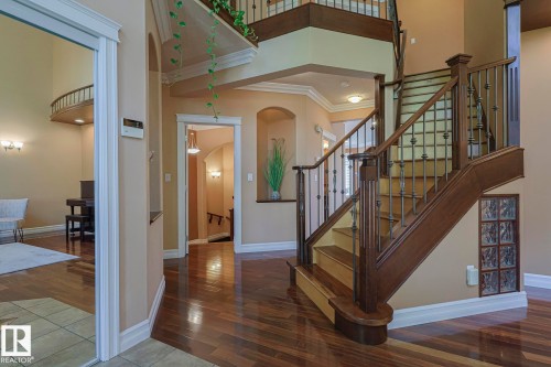 Grand entryway featuring a multi-level staircase with dark wood-finish railing and decorative metal balusters - 10731 150 Street Nw, Edmonton, AB - Indoor Photo Showing Other Room