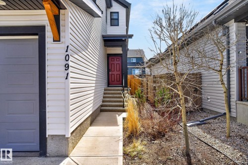 Modern exterior featuring white horizontal siding and dark trim accents - 1091 Secord Promenade, Edmonton, AB 
