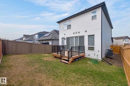 Rear exterior of the property featuring white horizontal siding and a dark trim - 1091 Secord Promenade, Edmonton, AB 