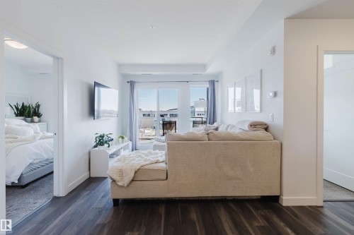 Living area with dark wood-finish flooring, white walls, and a recessed ceiling - 316 1316 Windermere Way, Edmonton, AB - Indoor Photo Showing Bedroom