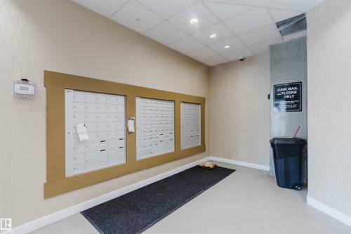 Wall-mounted mailboxes with a wood-finish surround - 316 1316 Windermere Way, Edmonton, AB - Indoor Photo Showing Other Room