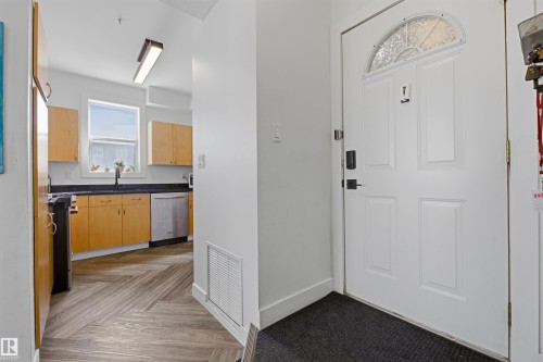 Entryway with a white paneled door featuring an arched decorative glass insert - 101 8108 109 Street, Edmonton, AB - Indoor
