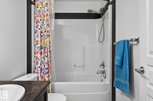 Bathroom featuring a white bathtub and shower combination with a single-handle faucet and showerhead - 21722 99A Avenue Nw, Edmonton, AB - Indoor Photo Showing Bathroom