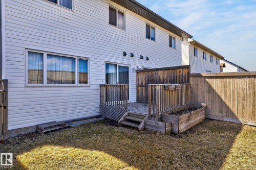 Rear exterior featuring white horizontal siding, a private wooden deck, and a raised planter box - 21722 99A Avenue Nw, Edmonton, AB - Outdoor With Exterior