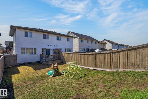 Fenced backyard featuring a wooden deck, sliding glass door access, and a manicured lawn - 21722 99A Avenue Nw, Edmonton, AB - Outdoor